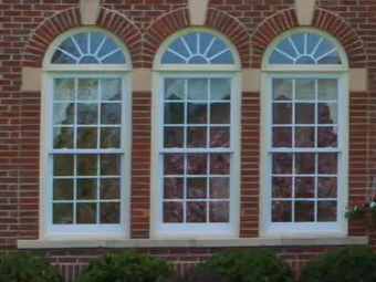 Artisan 143 Series arch-top windows on a brick home